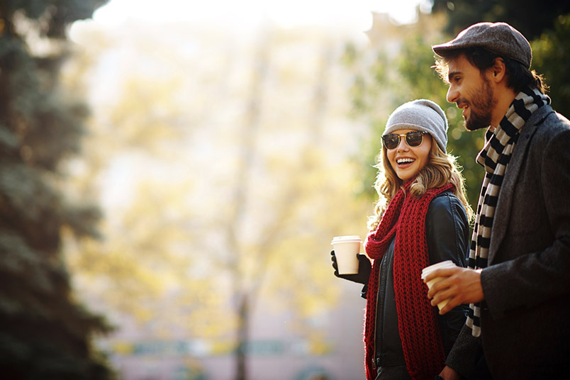 Man and Woman Smiling, Talking, Holding Cups of Coffee, Outdoors, Fall Season