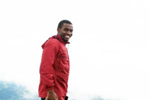 Young Man with Red Coat, Smiling, Outdoors On Mountain