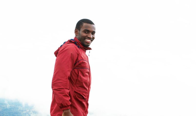 Young Man with Red Coat, Smiling, Outdoors On Mountain