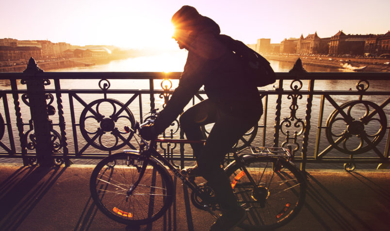 Man Riding Bike, European City, Bridge, River