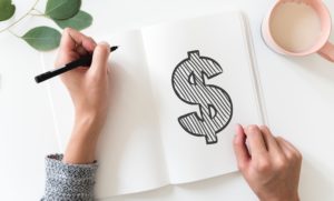 Woman drawing picture of money sign